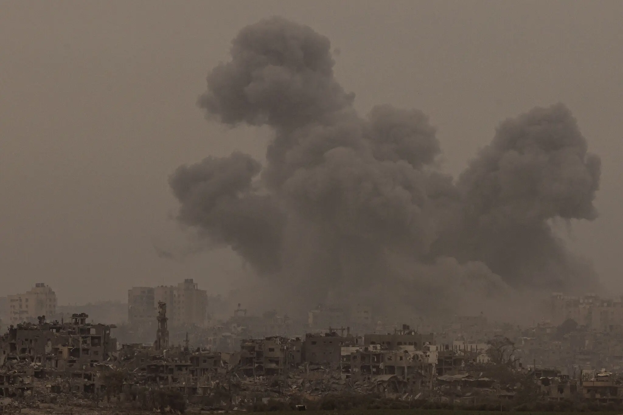 Дим від ізраїльських авіаударів піднімається над зруйнованими будівлями в секторі Газа в неділю